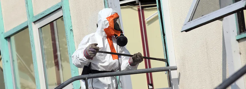 Retrait d'amiante en façade par un opérateur en protection respiratoire
