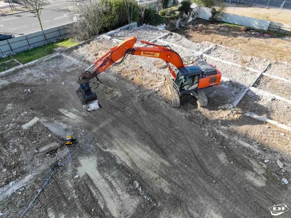 Vue aérienne d'un chantier de démolition avec pelle mécanique